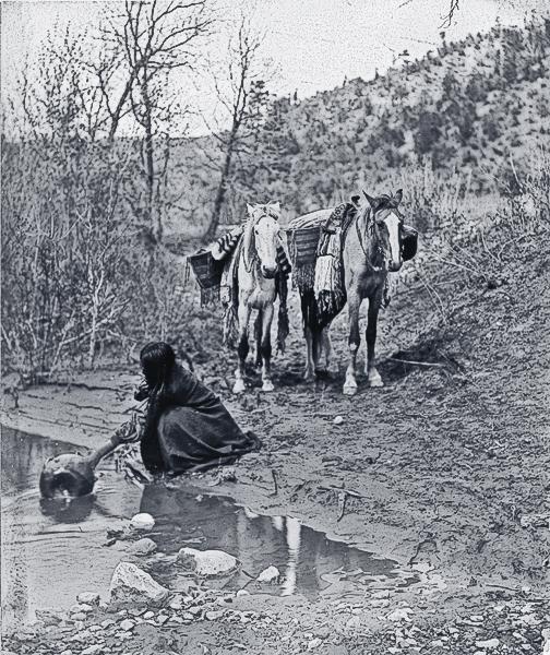 Apache Getting WaterApache women were skilled basket makers. Edward Curtis took this 1903 photograph of a woman filling her watertight basket with water to take back to camp.– Courtesy Library of Congress –