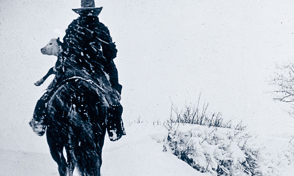 Pitchfork RanchCharles J. Belden’s poignant portrait of rancher Jack Rhodes Sr. saving a calf from the deep snows of winter in Wyoming in 1938-’39 captures the essence of a cowboy’s dedication to his work. – Courtesy Buffalo Bill Historical Center, Cody, Wyoming, Gift of Mr. and Mrs. Charles Belden –