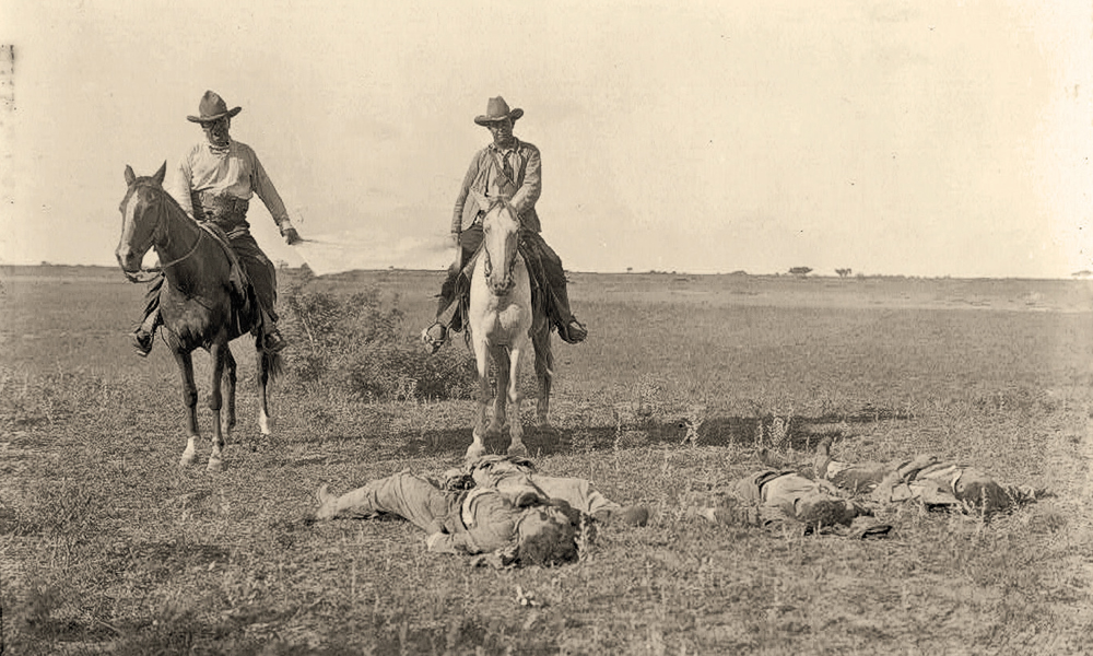 Frank Hamer posing with dead raiders