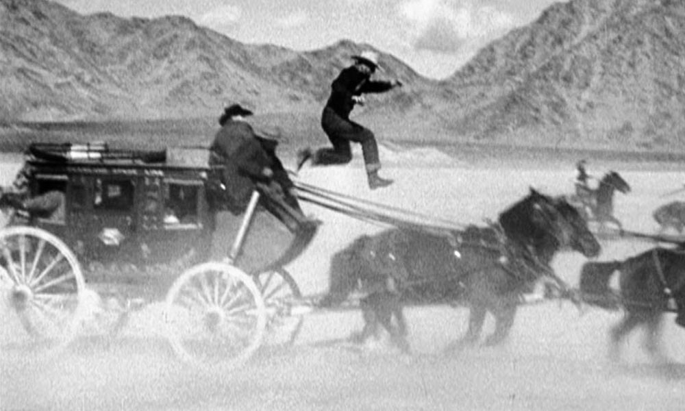 Yakima Canutt is shown in one of his most famous stunts from Stagecoach, doubling for John Wayne’s Ringo Kid as he jumps to steer a team of horses after the reins have fallen from wounded stage driver Buck’s hands. 